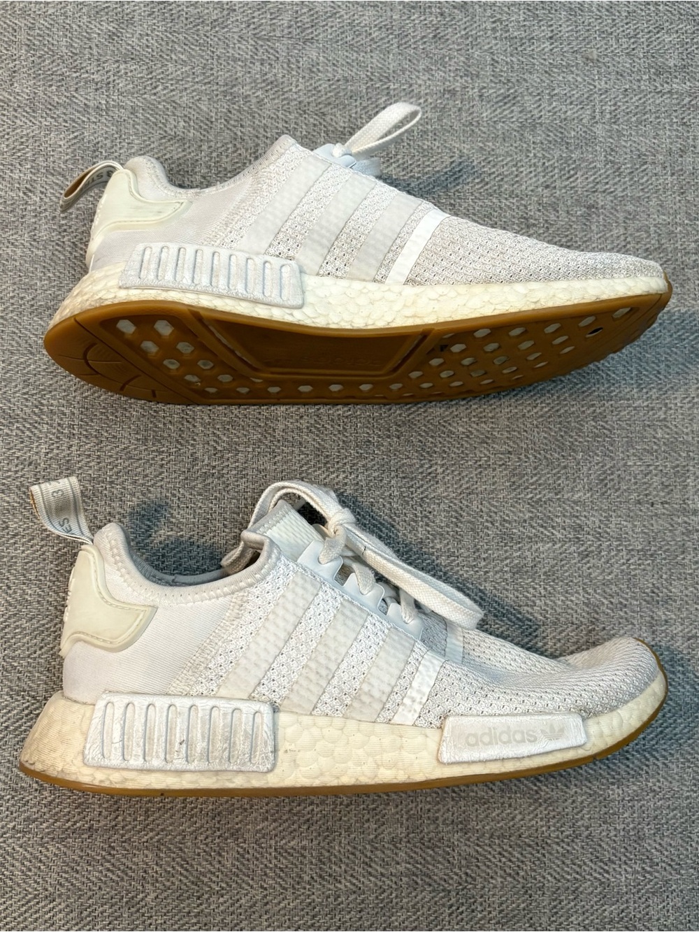 White Adidas NMDs athletic shoes